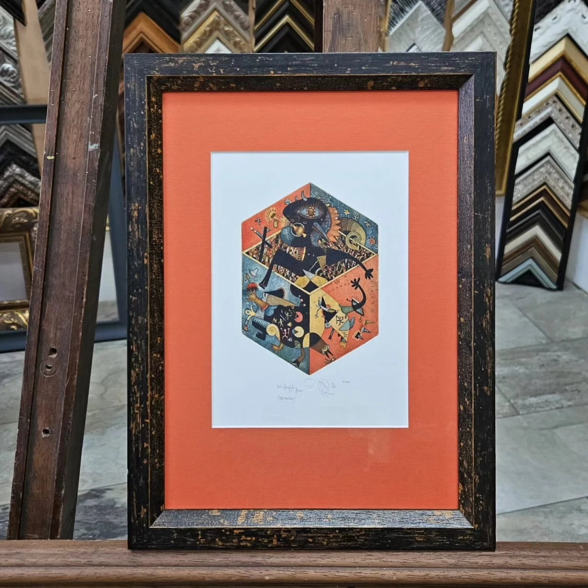 Oranžová pasparta okolo grafiky v tmavom ráme